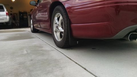 2002 Pontiac Grand Prix - Rear quarter panel and splash guard of a 2002 Pontiac Grand Prix, with another vehicle in the background.