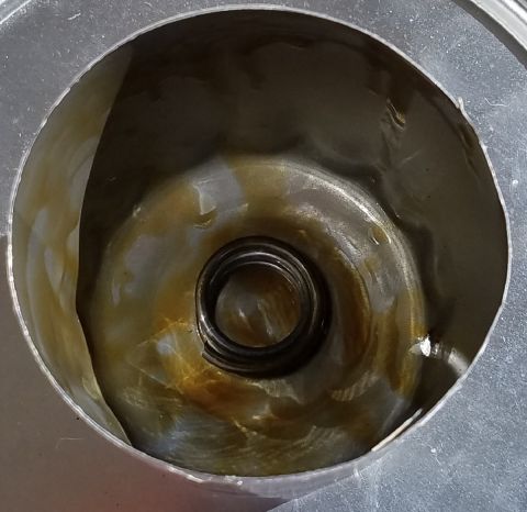 2000 Ford Crown Victoria - Close-up view of the interior of an oil filter housing, showing a spring and oil residue.