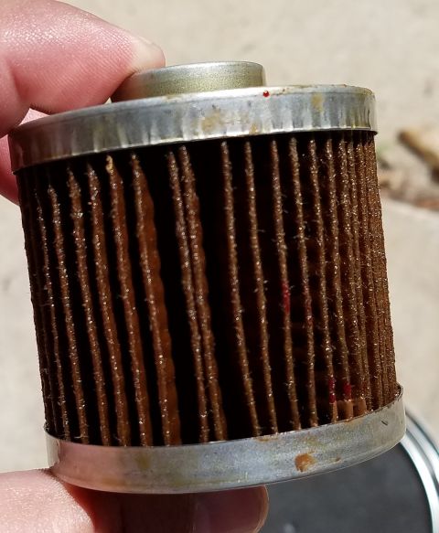 2000 Ford Crown Victoria - A used oil filter shows accumulated grime and debris on its filter media.