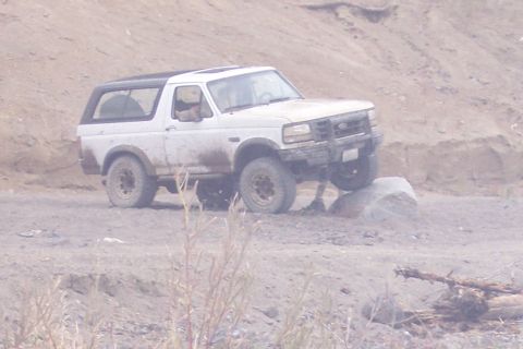 1995 Ford Bronco - A white Ford Bronco navigates a rocky off-road trail.