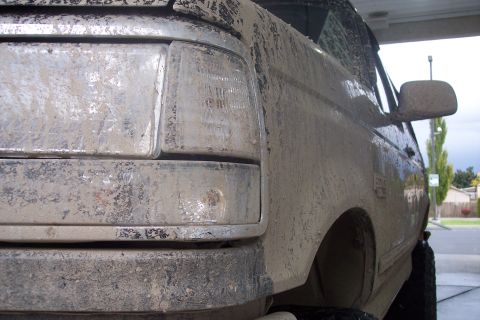 1995 Ford Bronco - This SUV is heavily covered in mud, obscuring most of its details and paintwork.