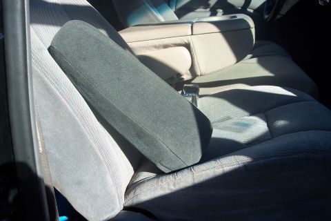 1995 Ford Bronco - The interior of a vehicle shows the front seats and a center console with an armrest.