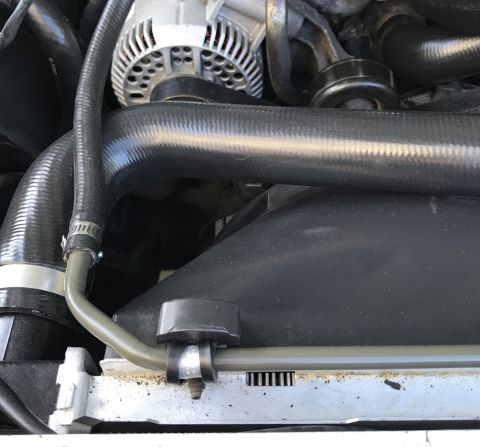 1995 Ford Bronco - Close-up view of engine components including the alternator and cooling system hoses.