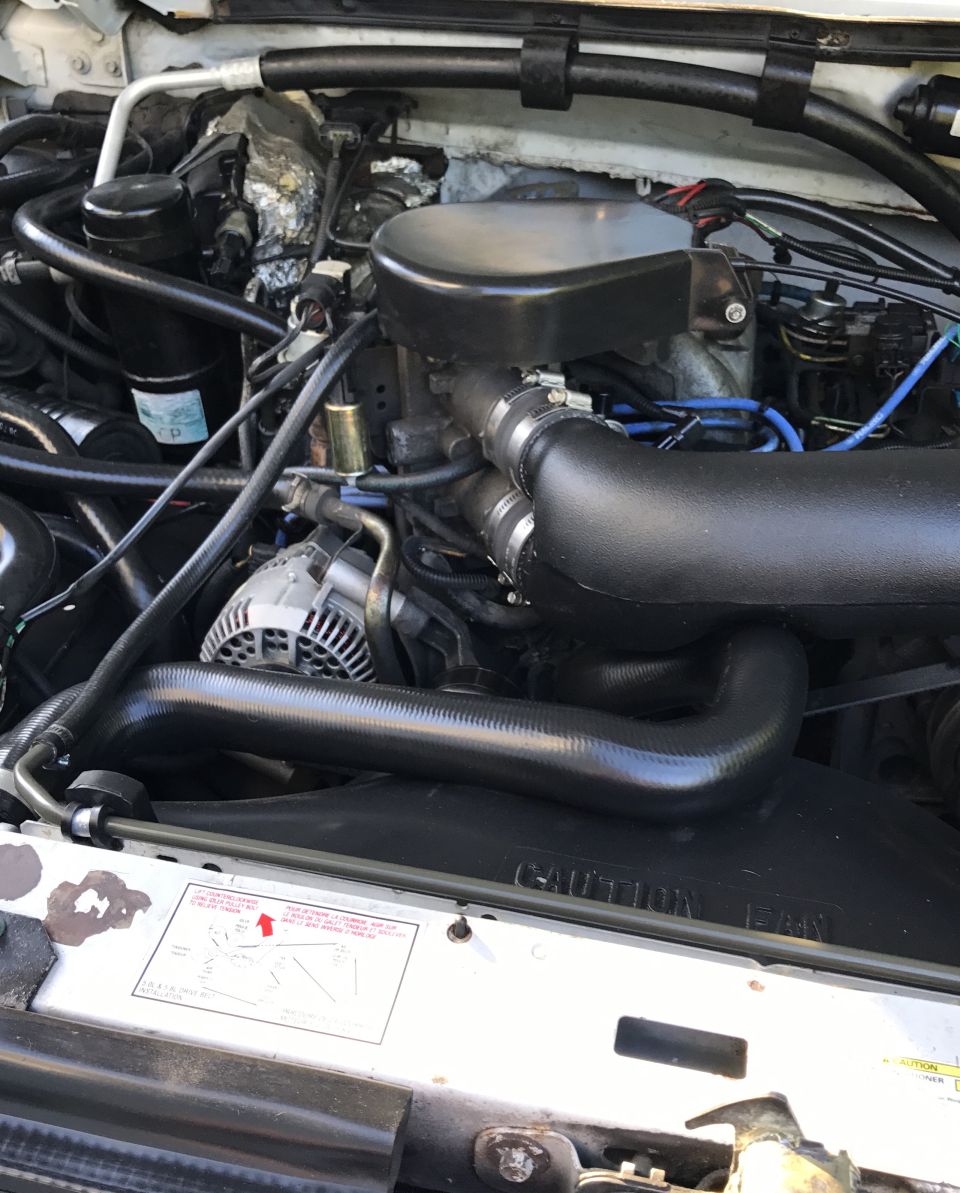 1995 Ford Bronco engine bay with black intake and alternator visible