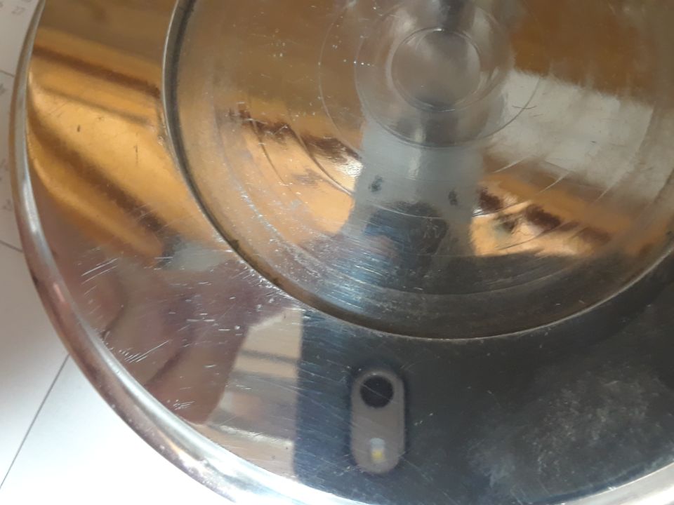 Machined metal part with concentric circles and a small sensor