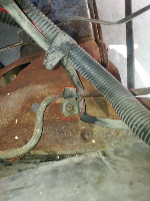1994 Ford Bronco - Detail of a rusted vehicle frame showing a wiring harness attachment point.
