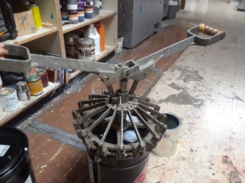 1994 Ford Bronco - A paint can spinner, likely used for mixing paint, is shown in a workshop setting with various cans and supplies in the background.