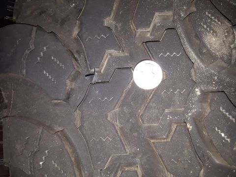 1985 Ford Bronco - A dime is placed on the tire tread to show its depth.