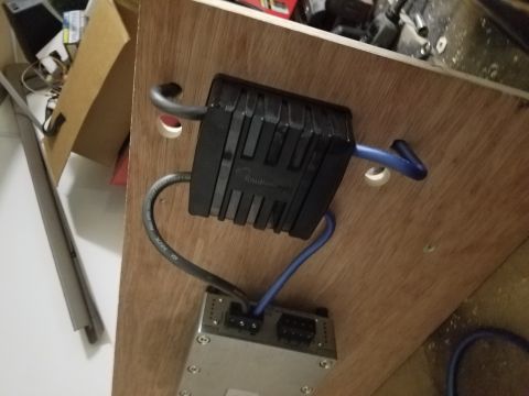 1994 Ford Bronco - Car stereo amplifier and capacitor are mounted on a wooden surface, with various wires connected.