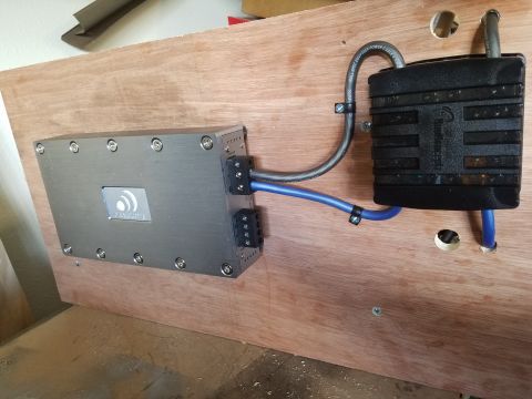 1994 Ford Bronco - Car amplifier and capacitor assembly mounted on wood, with visible wiring and mounting hardware.