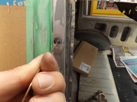 1962 MG B - Working on the door jamb of a vehicle interior, with boxes and papers in the background.