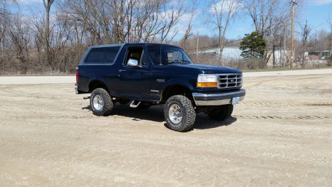 1995 Ford Bronco - This 1995 Ford Bronco, identified by its grille, is shown in a three-quarter front view on a dirt lot.