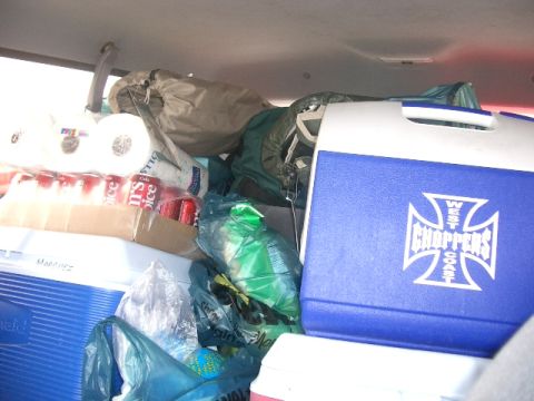 1994 Ford Bronco - The interior of a vehicle is filled with coolers, sleeping bags, and other supplies, suggesting a trip or move.