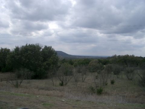 1994 Ford Bronco - A wide view of a rural landscape under a cloudy sky, with trees and hills visible.