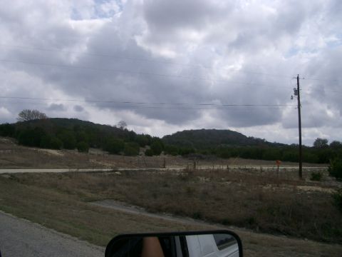 1994 Ford Bronco - A cloudy day over a rural landscape with hills and a prominent utility pole.