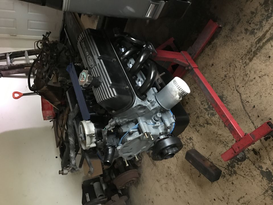 Engine on a red engine stand, looks like a Ford V8