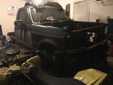 1995 Ford F-150 - Ford F-150 undergoing repairs in a garage with an ATV nearby.