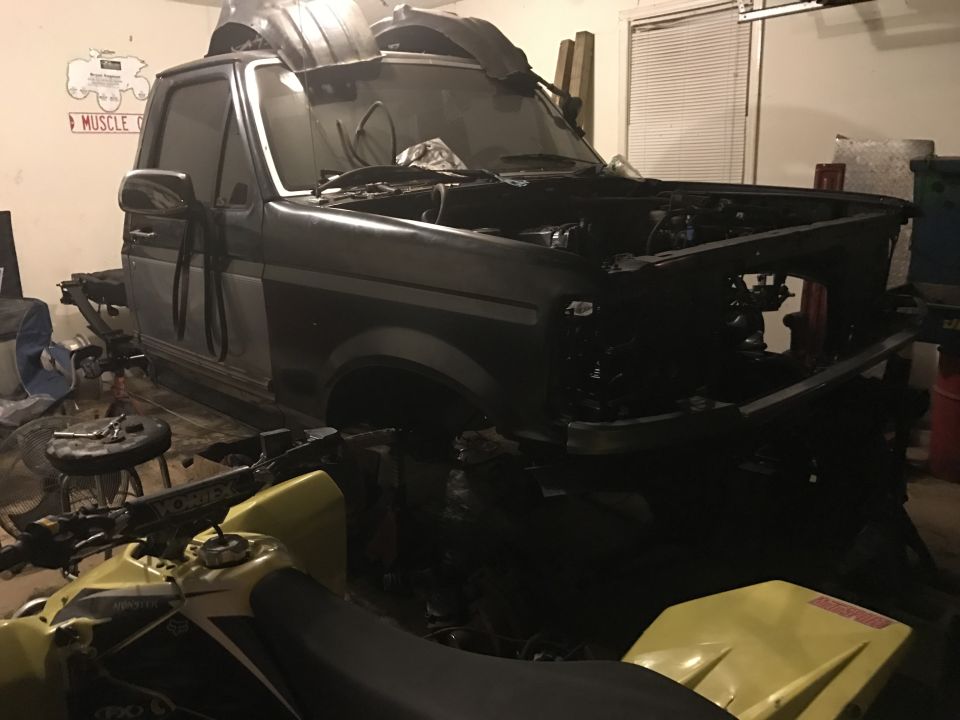 1995 Ford F-150 in garage, hood and front clip removed, yellow ATV in foreground