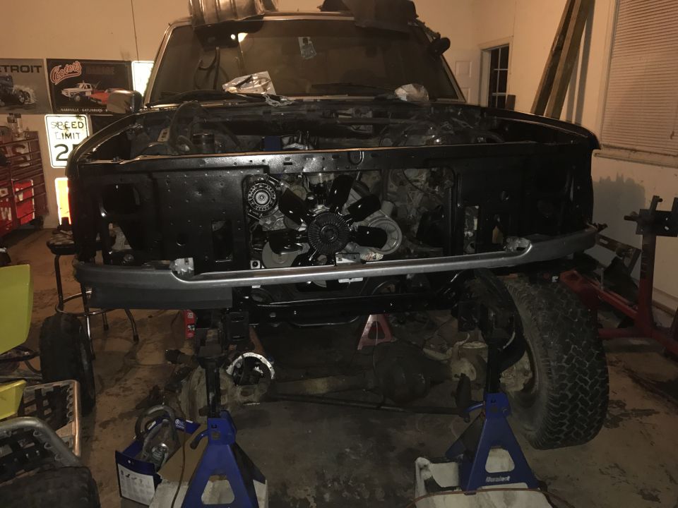Front view of a 1995 Ford F-150 with the hood and grille removed, showing the engine bay and front suspension disassembled