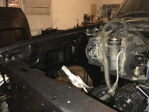 1995 Ford F-150 - The engine bay of a truck is shown with the hood open, revealing various mechanical parts and wiring.