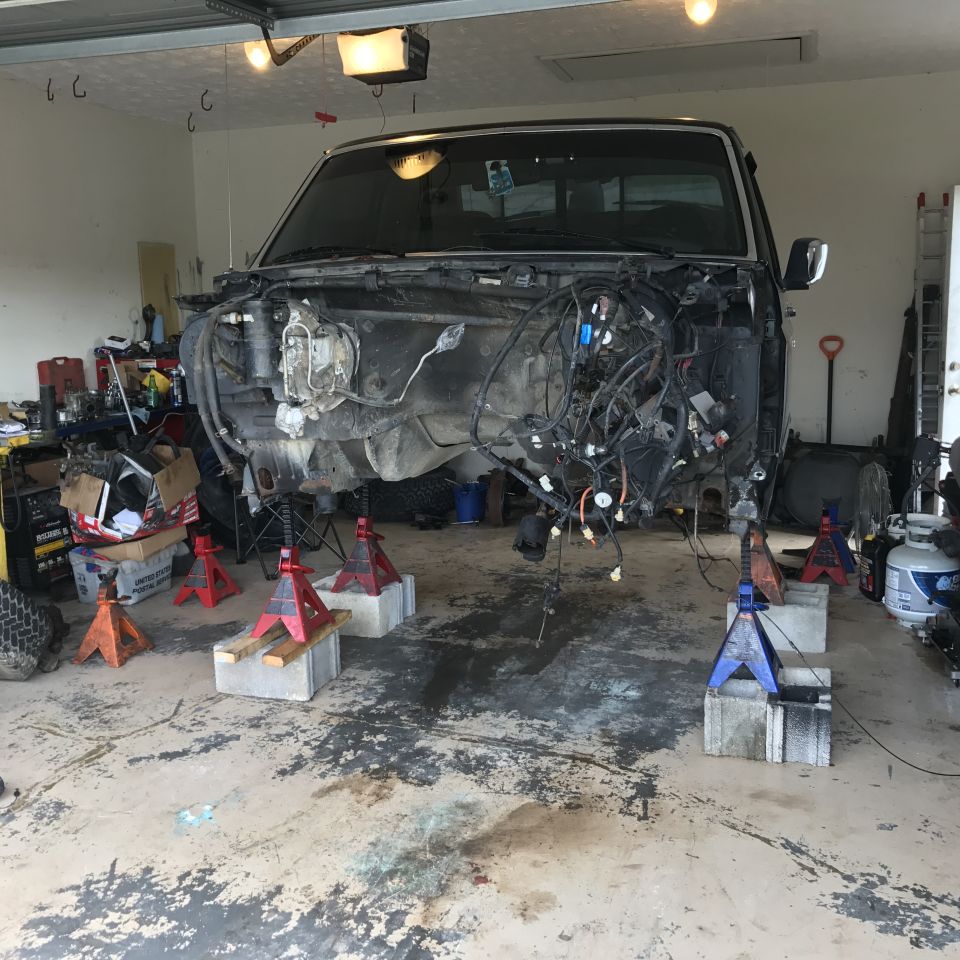 1995 Ford F-150 front end removed, truck raised on jack stands in garage