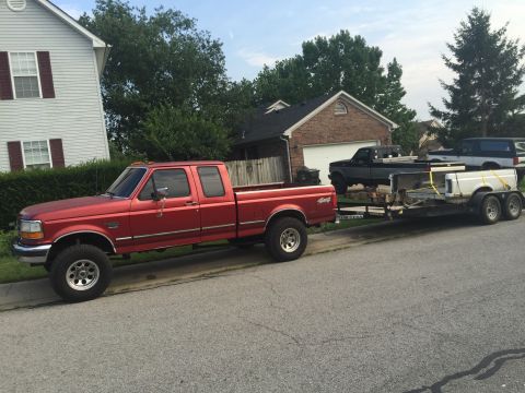 1995 Ford F-150 - Red 1995 Ford F-250 Super Duty crew cab long bed is towing a trailer with another truck on it.