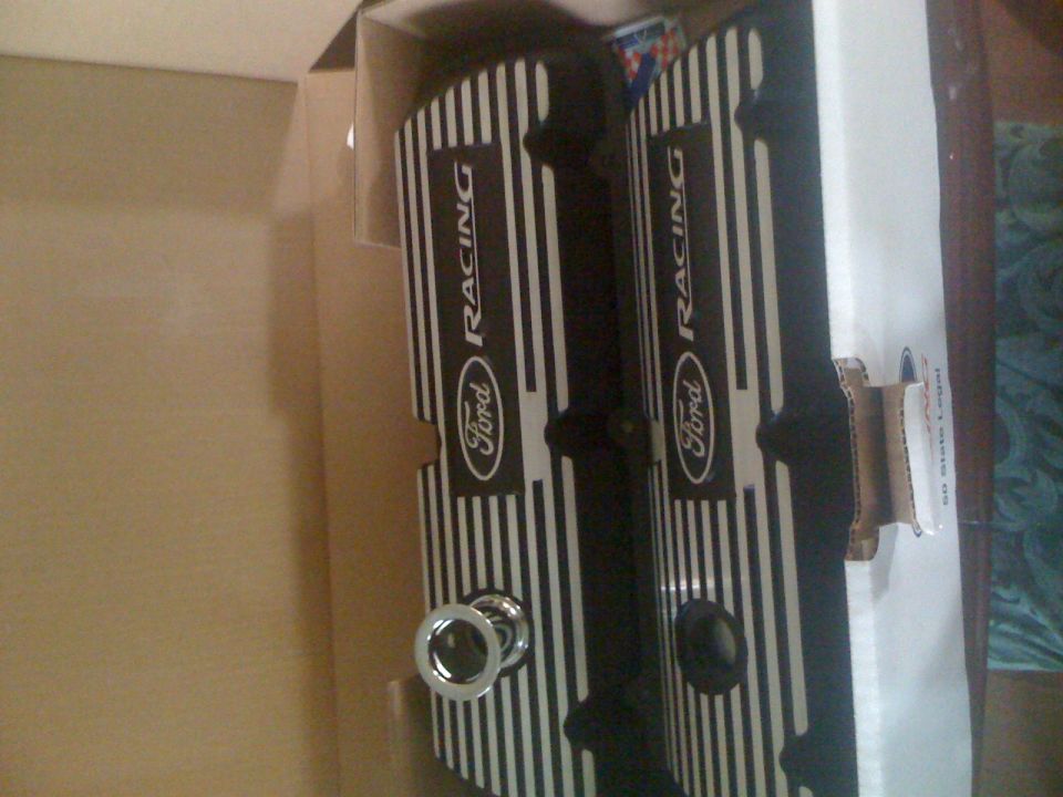 Two black Ford Racing valve covers with silver pinstripes in a box.