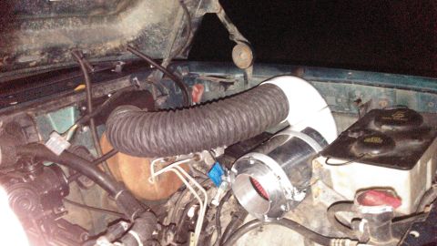 1996 Ford Bronco - Aftermarket air intake system installed in the engine bay of a vehicle.