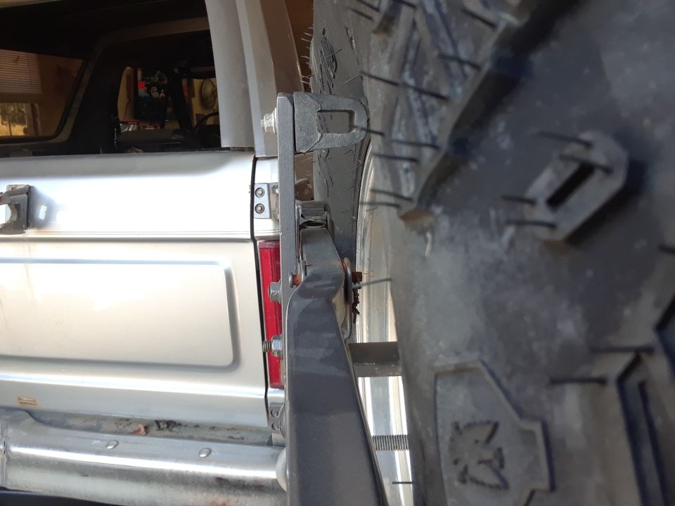 Silver SUV rear with spare tire on swing-away carrier