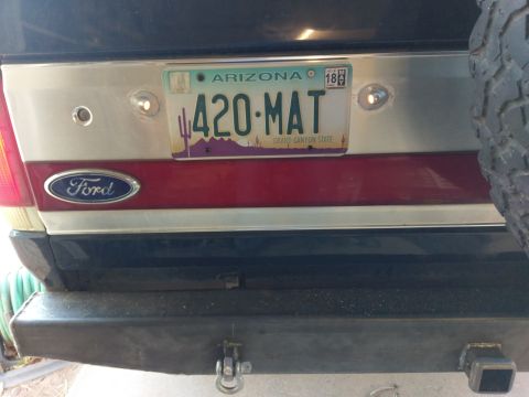 1988 Ford Bronco - The rear of a Ford Bronco is shown with a custom bumper and a license plate reading "420-MAT" from Arizona. The Ford logo is visible on the…
