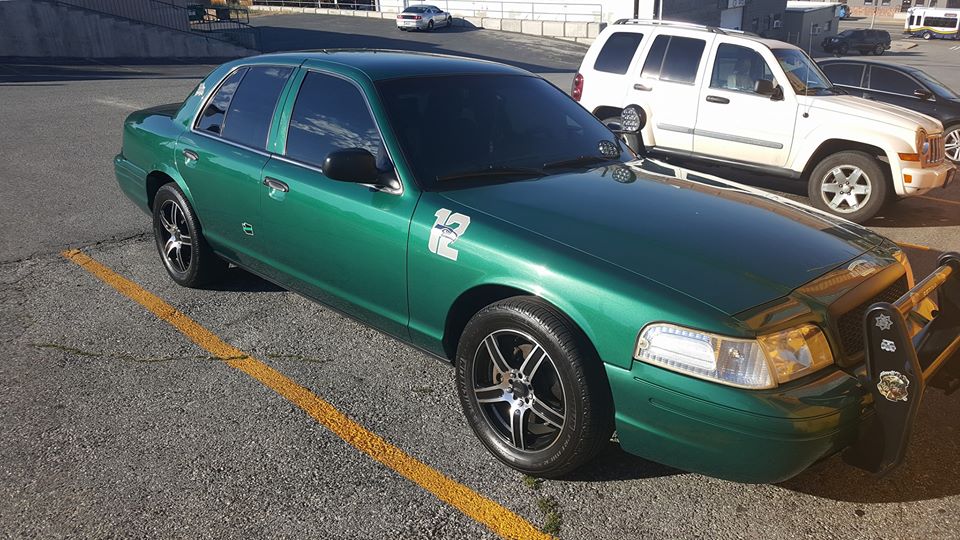 Green Ford Crown Victoria sedan with a push bar and a white "12" decal.