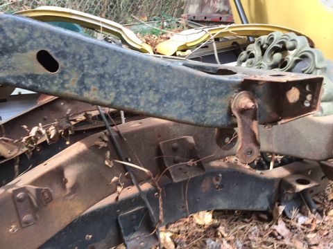 1994 Ford Bronco - Close-up view of a heavily rusted vehicle frame and suspension parts, suggesting a vehicle in disrepair.