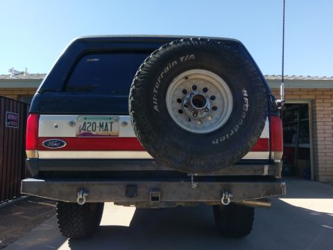 1988 Ford Bronco - The rear of a Ford Bronco shows a spare tire mounted on the tailgate and an aftermarket bumper.
