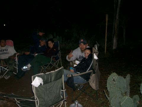 1994 Ford Bronco - A group of friends enjoys a nighttime gathering outdoors, with cacti visible in the dark.