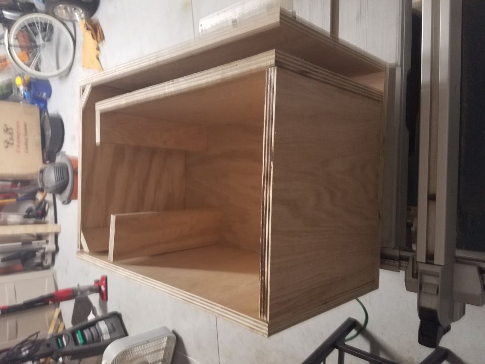 Wooden enclosure with multiple compartments, viewed from a slight angle