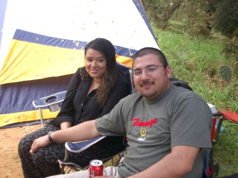 1994 Ford Bronco - A couple enjoys a camping trip with a tent set up in a grassy, wooded area.