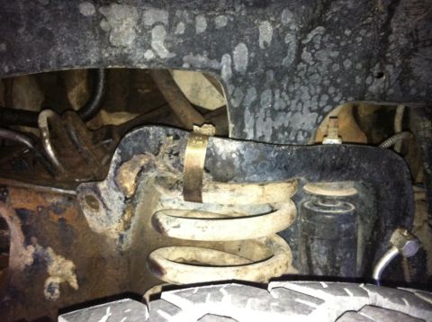 1987 Ford Bronco II - This image shows the undercarriage of a vehicle, focusing on the suspension system with visible rust and wear.