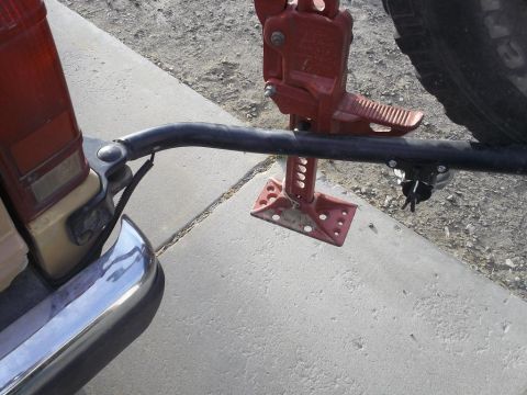 1987 Ford Bronco II - A hi-lift jack is mounted to the rear of a vehicle, ready for off-road use.