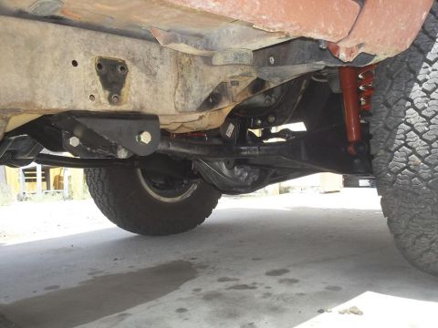 1987 Ford Bronco II - Close-up view of the underbody and suspension of an off-road vehicle, showing the frame and drivetrain components.