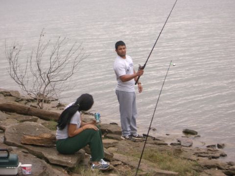1994 Ford Bronco - A man and a woman enjoy a day of fishing by the water, with fishing rods in hand.