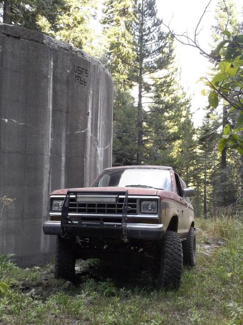 1987 Ford Bronco II - Ford Bronco II parked near a concrete structure with 'USFS 1966' visible.
