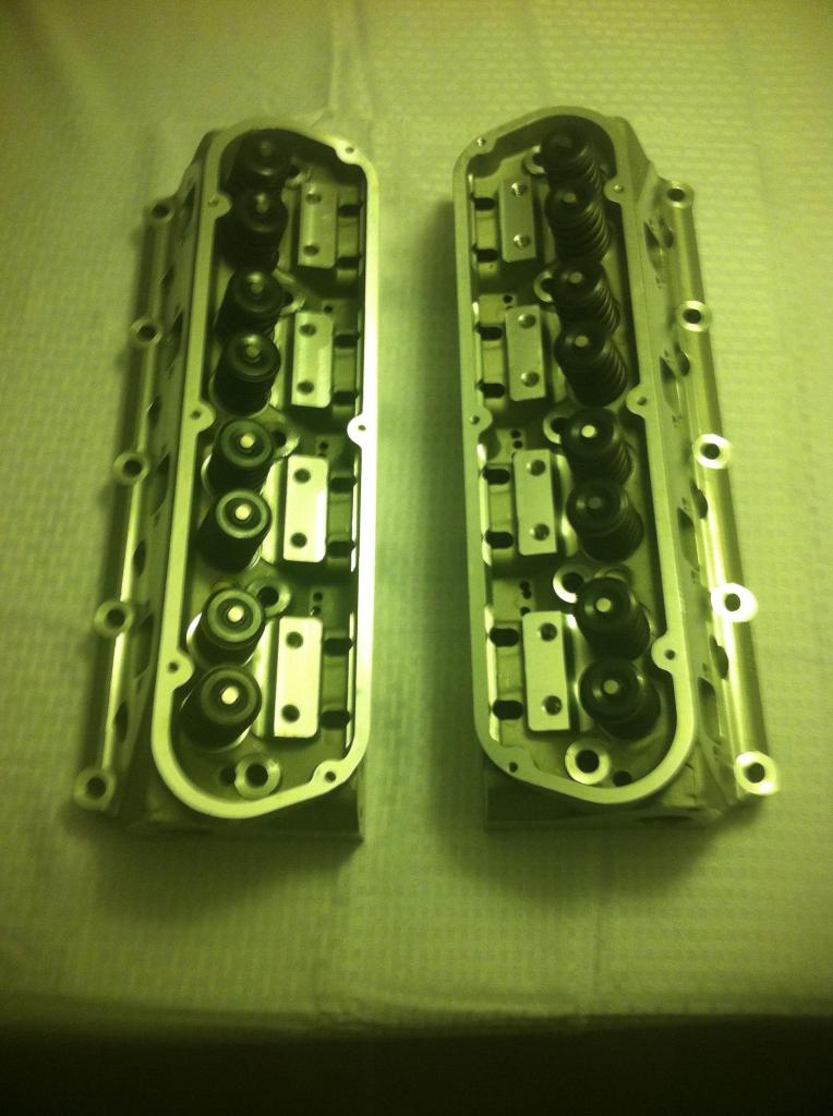 Two engine cylinder heads with valves and springs visible