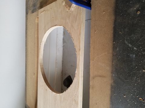 1994 Ford Bronco - Photograph of a wooden speaker enclosure panel showing a routed circular speaker opening.