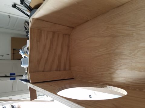 1994 Ford Bronco - Photograph looking into a plywood speaker box during assembly in a workshop.