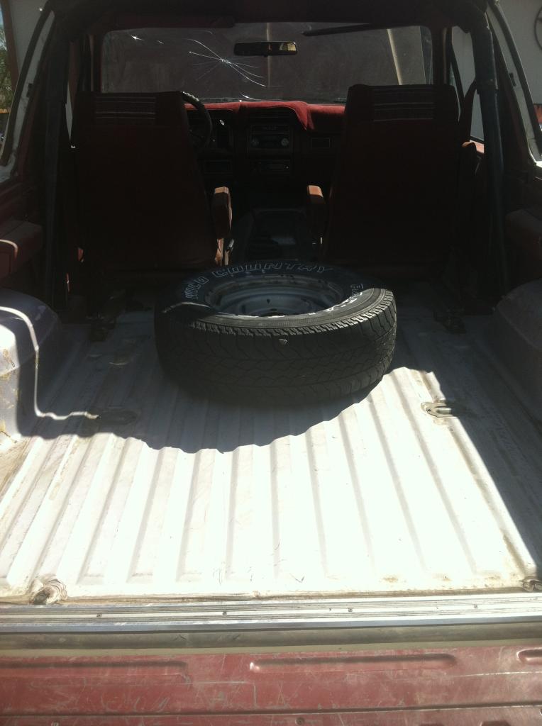 1984 Ford Bronco interior from rear, showing spare tire and front seats.