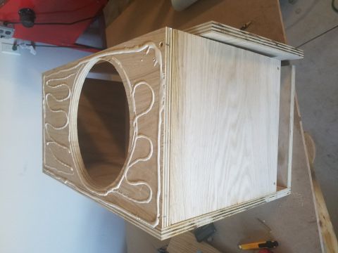 1994 Ford Bronco - Photograph of a plywood speaker enclosure with adhesive applied around the round speaker opening.