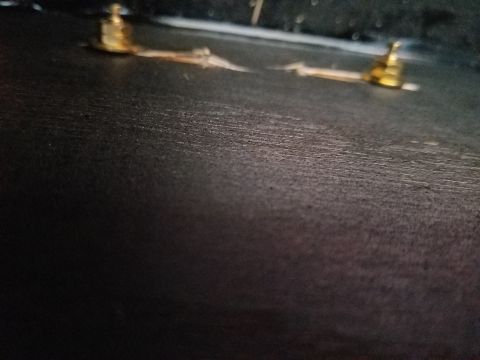 1994 Ford Bronco - Dark, blurry photograph of two gold binding-post terminals on a carpet-covered speaker box.