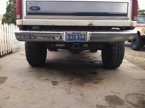 1984 Ford Bronco - The rear view of a lifted 1984 Ford Bronco shows its chrome bumper with a Nevada license plate reading "839-ASJ" and a U-Haul sticker. Two…