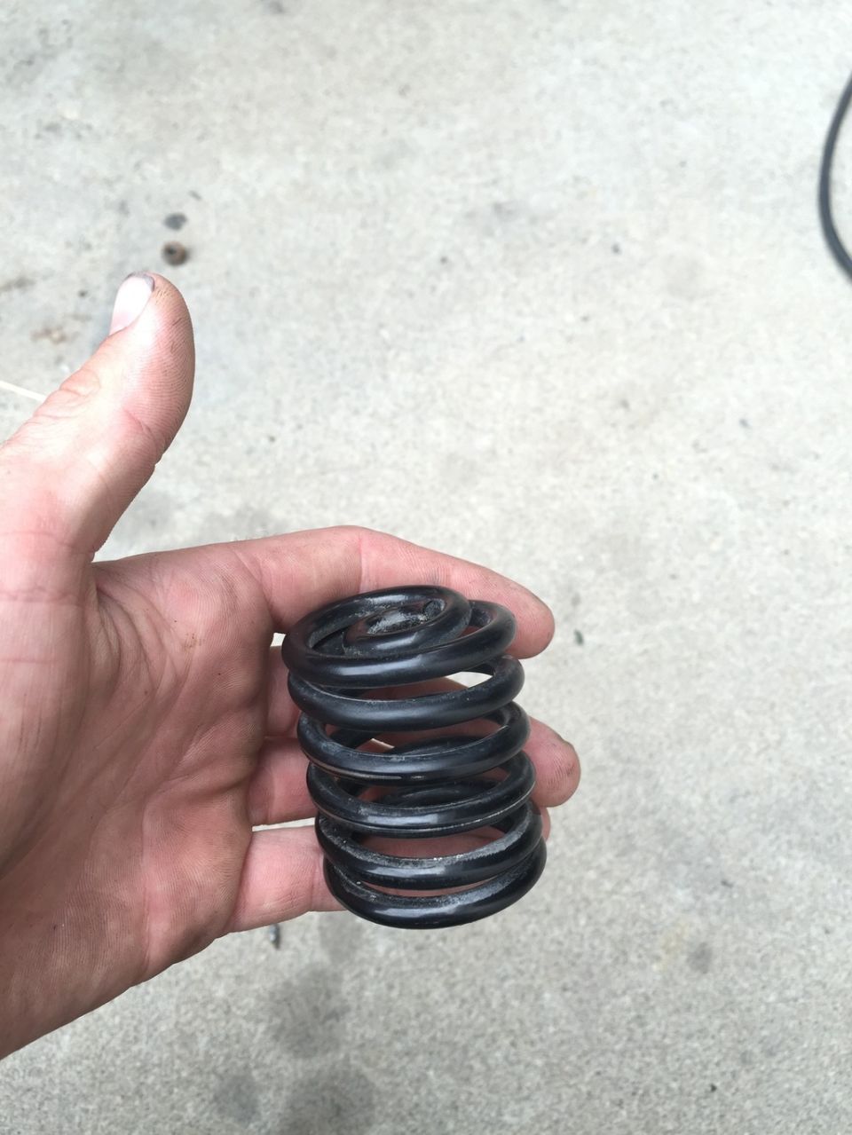 Hand holding a black coil spring