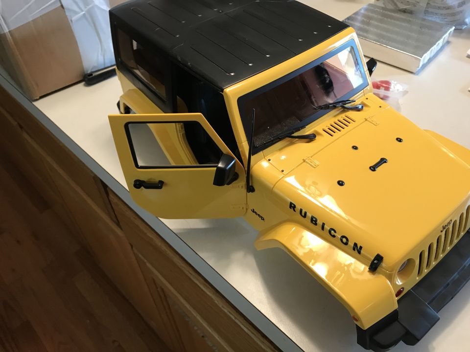 Yellow Jeep Wrangler Rubicon body with driver's door open.